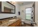 Bright bathroom featuring single vanity with granite top, shower and tub combo, and natural light at 2800 Resnik W Cir, Palm Harbor, FL 34683
