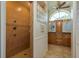 Bright bathroom boasts tiled walk-in shower, dual vanity, and large arched window at 2800 Resnik W Cir, Palm Harbor, FL 34683