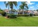Charming single-story home featuring lush landscaping, mature palm trees, and a well-manicured lawn at 2800 Resnik W Cir, Palm Harbor, FL 34683