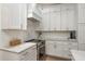 Close-up of the kitchen featuring white cabinets, marble countertops, and stainless steel appliances at 2800 Resnik W Cir, Palm Harbor, FL 34683