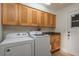 Bright laundry room with a washer and dryer, overhead storage, and a utility sink at 2800 Resnik W Cir, Palm Harbor, FL 34683