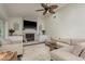 Bright living room features a stone fireplace, ceiling fan, and comfortable beige sofa and armchair at 2800 Resnik W Cir, Palm Harbor, FL 34683