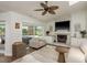 Comfortable living room with tile fireplace, ceiling fan, sliding door access to outdoor patio at 2800 Resnik W Cir, Palm Harbor, FL 34683