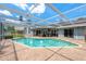Beautiful backyard pool with screened enclosure, patio seating, and inviting lounge area at 2800 Resnik W Cir, Palm Harbor, FL 34683