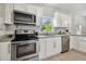 Modern kitchen with stainless steel appliances, granite countertops, and white cabinets at 2812 Tom Brewer Ln, Plant City, FL 33566