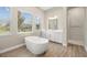 Bright bathroom with soaking tub, white cabinets, tiled floors, and natural light at 2839 Cordoba Ranch Blvd, Lutz, FL 33559