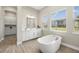 Bright bathroom with soaking tub, white cabinets, tiled floors, and natural light at 2839 Cordoba Ranch Blvd, Lutz, FL 33559