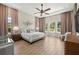 Spacious primary bedroom with wood floors, a ceiling fan, many windows, and elegant furniture at 2839 Cordoba Ranch Blvd, Lutz, FL 33559