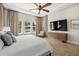 Bright main bedroom features a large bed, ceiling fan, and large television at 2839 Cordoba Ranch Blvd, Lutz, FL 33559