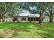 The backyard shows a beautiful yard, covered lanai and mature trees at 2875 Lomond Dr, Palm Harbor, FL 34684