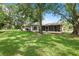 Beautiful backyard featuring green grass, mature trees and a covered lanai at 2875 Lomond Dr, Palm Harbor, FL 34684