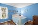 Bright bedroom features hardwood floors, a window, and calming blue walls at 2875 Lomond Dr, Palm Harbor, FL 34684
