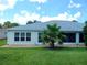 Backyard featuring a well-maintained exterior, grey roof, and a charming screened-in lanai at 29413 Caddyshack Ln, San Antonio, FL 33576