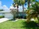 Charming single-story home featuring a lush green lawn, palm trees, and a well-maintained exterior at 29413 Caddyshack Ln, San Antonio, FL 33576
