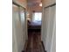 Hallway view leading to bedroom with wood laminate flooring, and closet doors on either side at 29413 Caddyshack Ln, San Antonio, FL 33576
