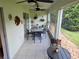 Screened patio featuring a ceiling fan, tile flooring, outdoor furniture and a view of the yard at 29413 Caddyshack Ln, San Antonio, FL 33576