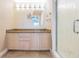 Bathroom featuring granite countertop, wooden drawers and a walk-in shower with glass doors at 399 150Th Ave # 315, Madeira Beach, FL 33708