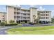 Well-maintained building exterior featuring multiple balconies, covered parking, and lush landscaping at 399 150Th Ave # 315, Madeira Beach, FL 33708