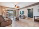 An inviting living area with a ceiling fan and a sliding door to a balcony overlooking lush scenery at 399 150Th Ave # 315, Madeira Beach, FL 33708