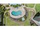 Aerial shot of the Kidney shaped pool surrounded by mature landscaping and plenty of lounge chairs at 399 150Th Ave # 315, Madeira Beach, FL 33708