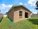 Side view of backyard featuring green grass, exterior wall, window and covered patio at 4079 Pacente Loop, Wesley Chapel, FL 33543