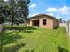 Spacious backyard featuring green grass, a large shade tree and covered patio at 4079 Pacente Loop, Wesley Chapel, FL 33543