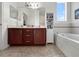 Bright bathroom with double sinks, garden tub, storage cabinet, and a large window at 4079 Pacente Loop, Wesley Chapel, FL 33543