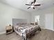 Bedroom with wood-look floors, grey fabric headboard, and view of the bathroom at 4079 Pacente Loop, Wesley Chapel, FL 33543