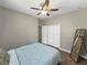 Cozy bedroom with ceiling fan, and closet space with a mirror and a bed at 4079 Pacente Loop, Wesley Chapel, FL 33543