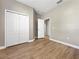 Bedroom featuring wood-look floors, a double door closet, and neutral paint at 4079 Pacente Loop, Wesley Chapel, FL 33543