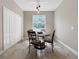 Bright dining area with a modern chandelier, table for four and beautiful tile flooring at 4079 Pacente Loop, Wesley Chapel, FL 33543