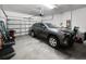 Attached garage featuring a garage door, seating and a newer model gray SUV at 4079 Pacente Loop, Wesley Chapel, FL 33543
