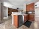 Kitchen with stainless steel dishwasher, wooden cabinets, and open view to living area at 4079 Pacente Loop, Wesley Chapel, FL 33543