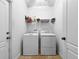 Laundry room equipped with a washer, dryer, shelving and tile floors at 4079 Pacente Loop, Wesley Chapel, FL 33543