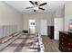 Spacious main bedroom with a ceiling fan, two dressers, and a door to the en-suite bathroom at 4079 Pacente Loop, Wesley Chapel, FL 33543
