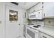 Practical kitchen featuring white appliances, tiled flooring, and ample cabinet storage at 4143 Gray Squirrel Ln, New Port Richey, FL 34653