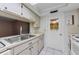 White kitchen offering plenty of counter space, storage, and white tiled floors at 4143 Gray Squirrel Ln, New Port Richey, FL 34653