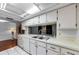 Well-lit kitchen with white cabinets, appliances, and a double basin stainless steel sink at 4143 Gray Squirrel Ln, New Port Richey, FL 34653