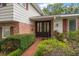 Elegant entryway with a double door, brick pathway, and manicured shrubbery at 4146 Harbor Hills Dr, Largo, FL 33770