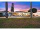Backyard view of the home featuring a pool, screen lanai, and green grass in a serene outdoor space at 4252 Floramar Ter, New Port Richey, FL 34652
