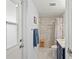 Bathroom showcasing a tiled shower with glass door, blue vanity, and neutral color palette at 4252 Floramar Ter, New Port Richey, FL 34652