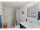 Bathroom featuring a tiled shower, a vanity with solid surface countertop, and decorative light fixture at 4252 Floramar Ter, New Port Richey, FL 34652