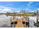View of a wooden dock on a canal with waterfront homes and boats under a blue sky with white clouds at 4252 Floramar Ter, New Port Richey, FL 34652