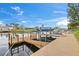 Dock with boat lift shows waterfront access to the home with calm canal waters and blue skies at 4252 Floramar Ter, New Port Richey, FL 34652