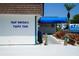 Exterior view of the Gulf Harbors Yacht Club with its sign and blue awning entrance at 4252 Floramar Ter, New Port Richey, FL 34652