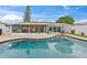 Lush backyard oasis featuring a sparkling pool, screened-in lanai, and beautiful landscaping, ideal for relaxation and enjoyment at 4252 Floramar Ter, New Port Richey, FL 34652
