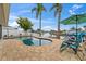 Relaxing backyard with a beautiful pool, canal view, lush palm trees, and lounge chairs perfect for sunny days at 4252 Floramar Ter, New Port Richey, FL 34652