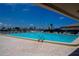 Community swimming pool on a sunny day, showcasing lounge chairs and tall masts of sailboats in the background at 4252 Floramar Ter, New Port Richey, FL 34652