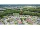 Aerial view of homes in a residential neighborhood, with a mix of housing styles and landscaping, near a pond and a highway at 4634 Mapletree Loop, Wesley Chapel, FL 33544