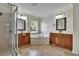 Bathroom with a soaking tub, dual sinks, wooden cabinets, shower, and tile floors at 4634 Mapletree Loop, Wesley Chapel, FL 33544